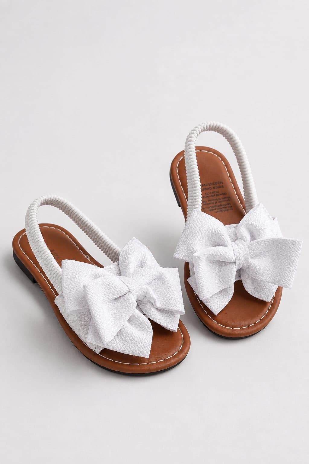 SANDALIAS BLANCAS CON MOÑO Y CORREA TRENZADA — zapatos para niña
